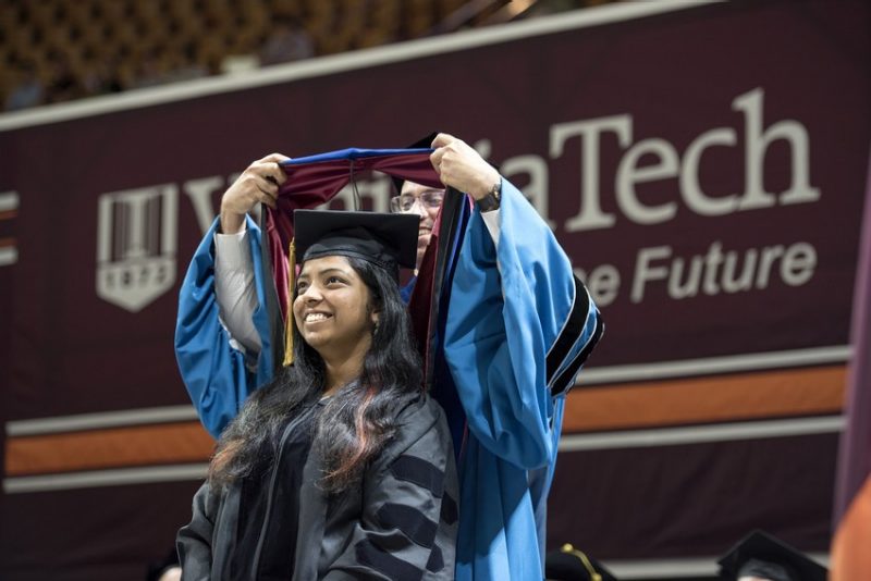 A graduate is hooded at a graduate school commencement ceremony. Virginia Tech