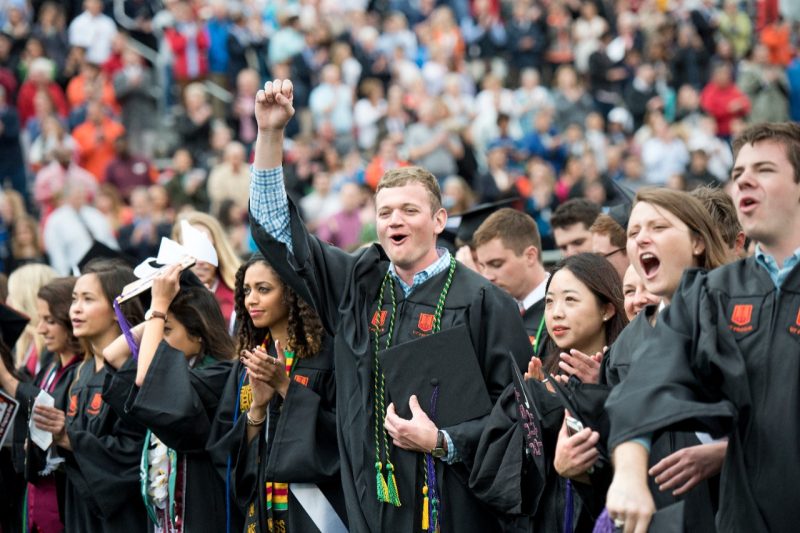 Graduates cheer at a commencement ceremony.