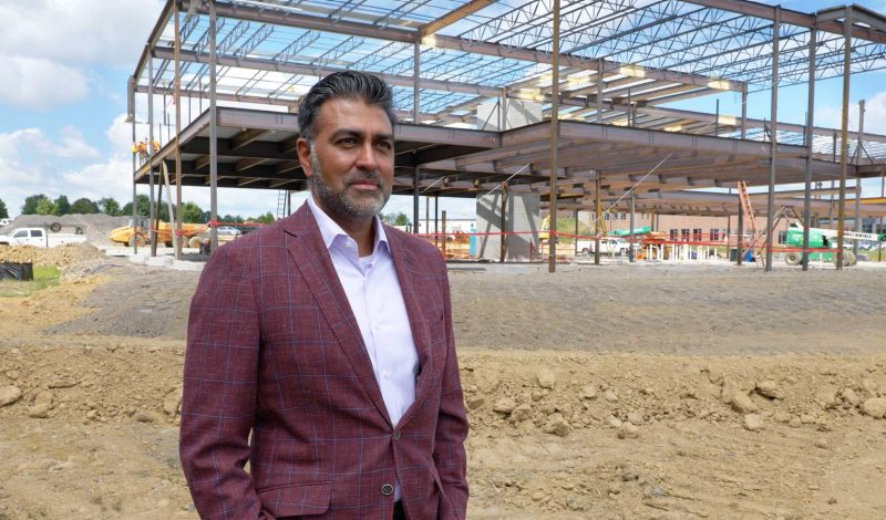 Photo of Sonu Singh of 1901 Group standing in front of his company's new building.