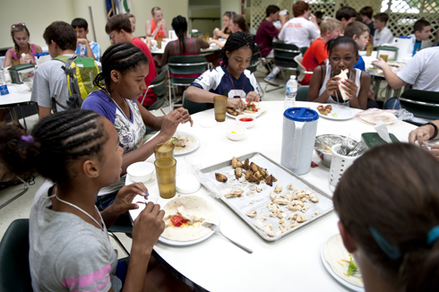 4-H campers enjoy chicken soft tacos topped with tomatoes, lettuce, and cheese with a side of potatoes.