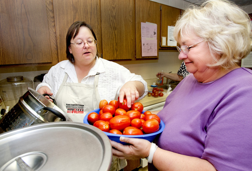 Floyd County Master Food Volunteer Rebecca Shannon, at left, teaches participants to safely roast and can tomatoes.