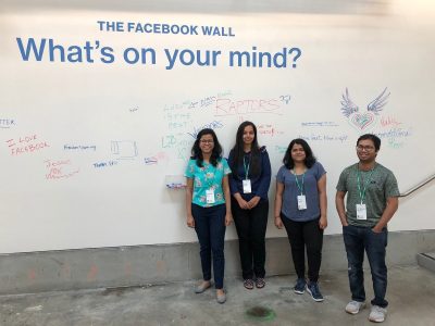 Tanushree Mitra and her students standing in front of The Facebook Wall 