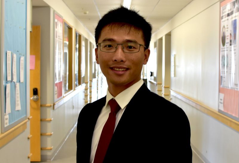 In a photo from 2016, Assistant Professor Lin Feng poses wearing a suit and tie at Hahn Hall North.