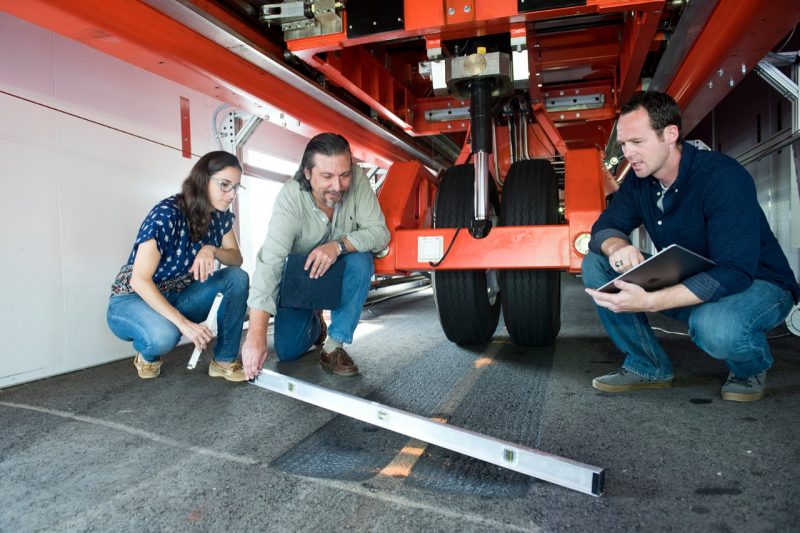 Researchers under a vehicle